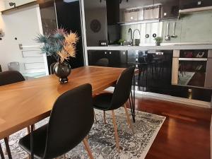 cocina con mesa de madera y sillas negras en Apartment Bella Vita en Zagreb