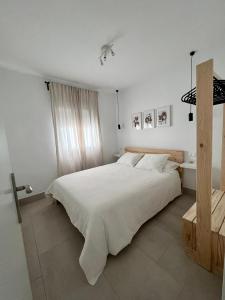 Un dormitorio blanco con una gran cama blanca. en Alojamiento Rural Buenavista, en Arcos de la Frontera