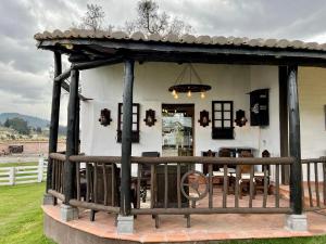 a wooden gazebo with a table and chairs at Hacienda Santa Ana Lodging in Guamote