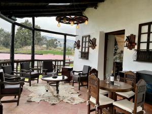 a patio with tables and chairs and a large window at Hacienda Santa Ana Lodging in Guamote