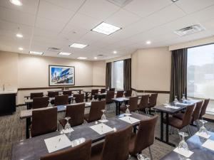a conference room with tables and chairs and a projection screen at Holiday Inn Greensboro Coliseum by IHG in Greensboro +25 photos