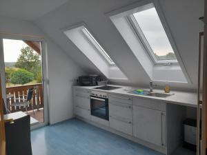 a kitchen with skylights and a sink and a stove at Ferienwohnung Ina in Michelau