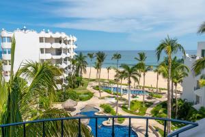 a view of the pool and beach from the balcony of a resort at Beach Front Mykonos in San José del Cabo