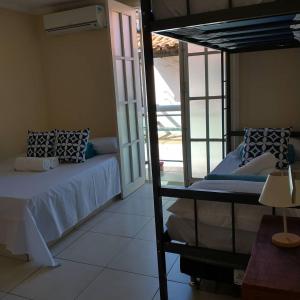 1 dormitorio con litera y balcón en Casa Maravilhosa com 6 quartos na Praia Grande - Arraial do Cabo, en Arraial do Cabo