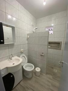 a bathroom with a toilet and a sink at Casa na Praia da Pinheira in Palhoça