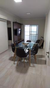 a dining room with a glass table and chairs at Apartamento Praia Grande -Canto do Forte in Praia Grande