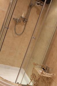 cabina de ducha con puerta de cristal y silla en George & Dragon, en Aysgarth