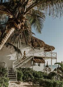 a person sitting on the stairs of a building on the beach at Coco Unlimited in Tulum