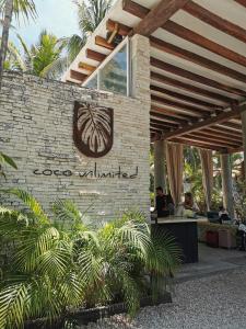 a sign for a hotel with people sitting at a table at Coco Unlimited in Tulum