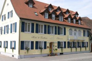 un edificio con persianas azules y techo rojo en Hotel-Restaurant Schwanen, en Weil am Rhein