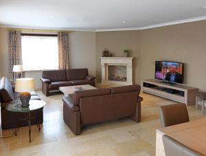 ein Wohnzimmer mit einem Sofa und einem TV in der Unterkunft Villa 't Uze in De Panne