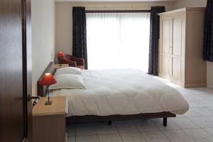 ein Schlafzimmer mit einem großen Bett und einem Fenster in der Unterkunft Villa 't Uze in De Panne