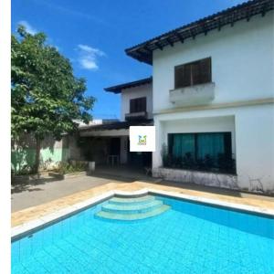 a swimming pool in front of a house at Pousada Kavili 150m da Praia in Guarujá