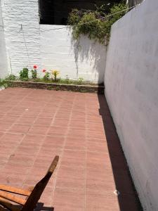 a bench sitting on a sidewalk next to a wall at Pequeño y cómodo in Florida