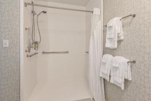 a bathroom with a shower with white towels at Holiday Inn Express & Suites Jersey City - Holland Tunnel, an IHG Hotel in Jersey City