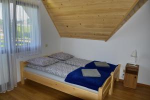 1 dormitorio con cama con sábanas azules y ventana en Domek u Zbyszka, en Groń