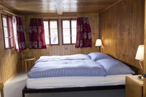 Cama en habitación con paredes y ventanas de madera en Hannig en Saas-Fee