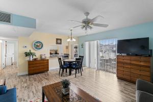 a living room with a table and a ceiling fan at #231 E Madeira Beach Yacht Club in St. Pete Beach
