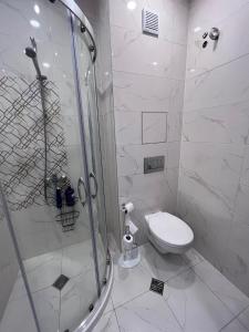 a white bathroom with a shower and a toilet at Paris luxury top centre Apt with office space in Sofia