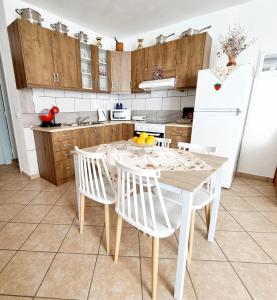 a kitchen with a table and chairs and a white refrigerator at Sweet Stone House in Hydra
