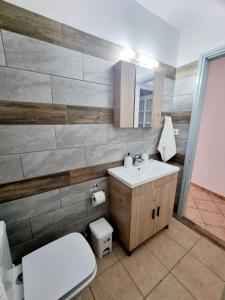 伊茲拉的住宿－Sweet Stone House，浴室配有白色卫生间和盥洗盆。