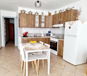 a kitchen with a table and a white refrigerator at Sweet Stone House in Hydra