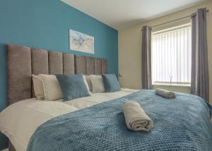 1 dormitorio con 1 cama grande y pared azul en Ground Floor Apartment Private Parking Sleeps 5 near City Centre and Shopping Centre en Birmingham