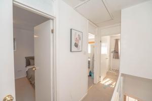 a white room with a door and a mirror at #Gorgeous 3 beds home#7min to subway, free parking in Thamesmead