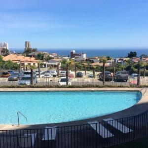 - une piscine avec vue sur un parking dans l'établissement Apartment Concón, à Concón