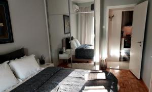 Schlafzimmer mit einem Bett und einem Spiegel in der Unterkunft Fully equiped Design Apartment with excellent view/ easy parking in Athen