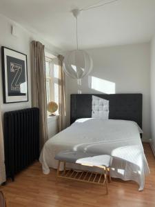 a bedroom with a large white bed and a chair at The Photographer's House in Höganäs in Höganäs