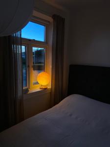 um quarto com uma cama e uma janela com um candeeiro em The Photographer's House in Höganäs em Höganäs