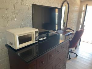 a microwave sitting on top of a desk with a tv at Stratford House Inn in Branson