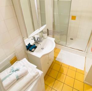 La salle de bains blanche est pourvue d'un lavabo et d'une douche. dans l'établissement Le Croix Rousse Jacquard, à Lyon