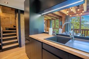 a kitchen with a sink and a staircase at Hauts de Chantemouche 17 in Méribel +15 photos