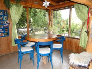 een eetkamer met een houten tafel en blauwe stoelen bij Abedules in Dina Huapi