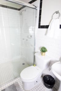 een witte badkamer met een toilet en een douche bij LA CONDESA: BEAUTIFUL DESIGNED STUDIO in Mexico-Stad