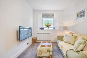 sala de estar con sofá y TV en Tramontane Apartment at Hesketh Crescent, en Torquay