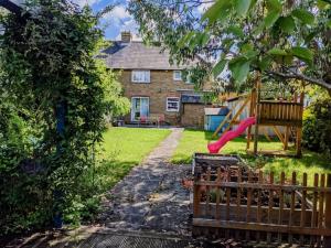 a backyard with a playground with a slide at Magnolia cove in Whitstable