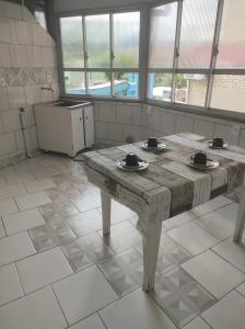 uma cozinha com uma mesa de madeira num quarto em Apartamento amplo pé na areia - Itapema 180m da Praia em Itapema