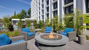 a patio with chairs and a fire pit in front of a building at Holiday Inn San Jose-Silicon Valley by IHG in San Jose