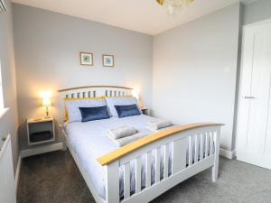 a bedroom with a white crib with blue pillows at 4 Plas Newydd in Llandudno