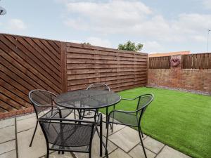 a patio with a table and chairs and a fence at 4 Plas Newydd in Llandudno