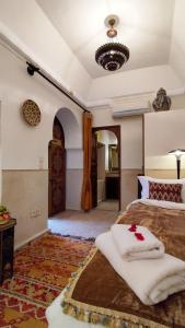 a bedroom with a bed with white towels on it at RIAD DAR En-Nawat in Marrakesh