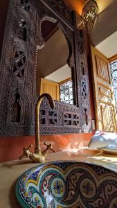 a bathroom sink with a faucet in front of a mirror at RIAD DAR En-Nawat in Marrakesh