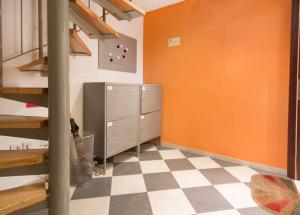 a room with an orange wall and a checkered floor at Rainbow Rooms in Ljubljana
