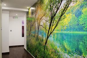 mural de un lago y árboles en una pared en Luwiana Suites, en Liubliana