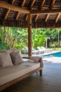 a bed sitting under a pergola next to a pool at Casa Vida : Charme, Comforto e Localização in Trancoso