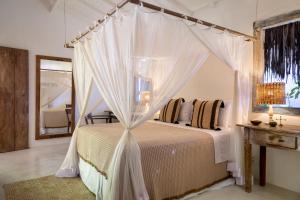 a bedroom with a bed with a canopy at Casa Vida : Charme, Comforto e Localização in Trancoso