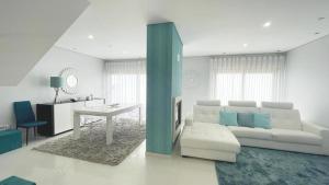 ein Wohnzimmer mit einem weißen Sofa und einem Tisch in der Unterkunft Sunset Street Beach house in Lourinhã